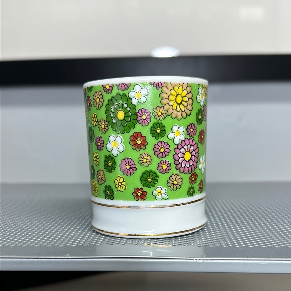 Green and Yellow Floral Ceramic Cup with Playful Daisy Pattern.